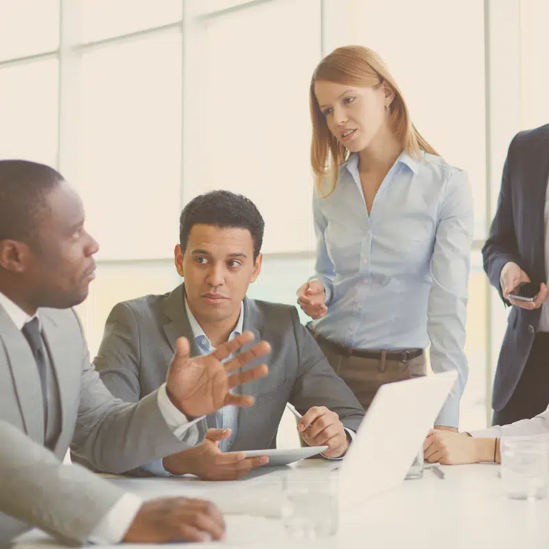 Legal Services for Friendswood Texas shows four people in business attire having a discussion